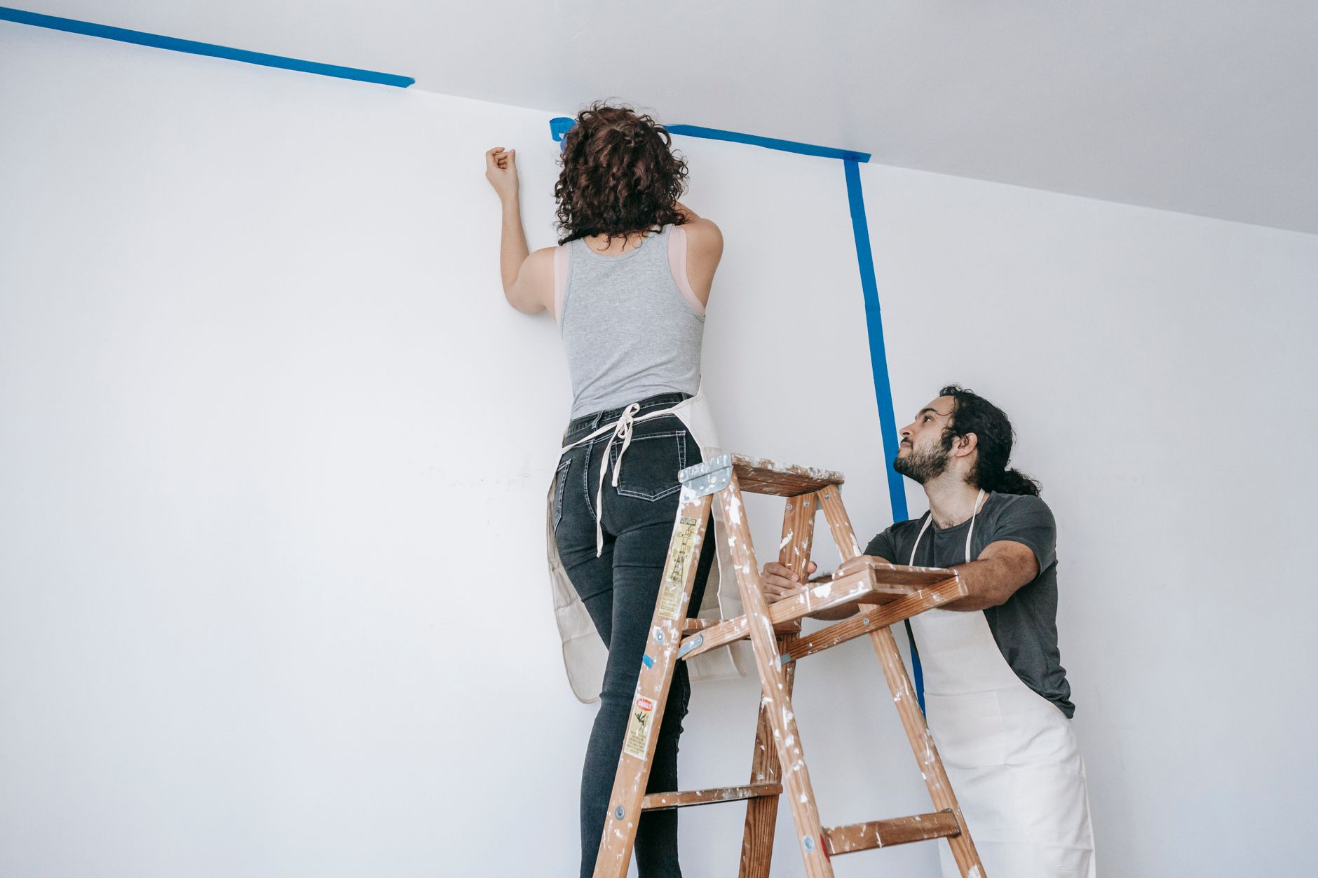 A couple collaborates on home renovation with paint and ladder in Riverside, CA